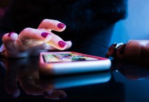 Nell'immagine la mano di una donna scrolla sullo smartphone - Smart Marketing