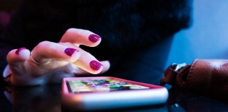 Nell'immagine la mano di una donna scrolla sullo smartphone - Smart Marketing