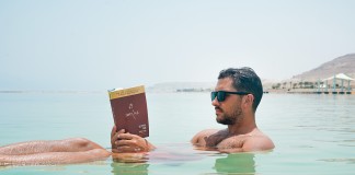 Nell'immagine un ragazzo legge un libro mentre galleggia sul mare - Smart Marketing