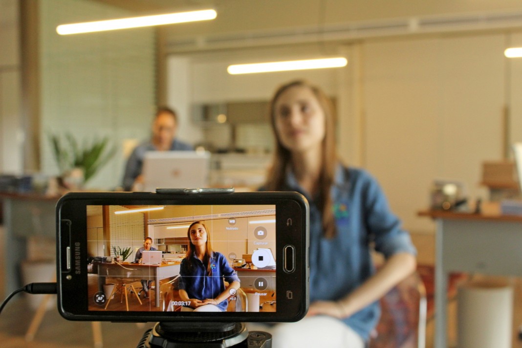Nell'immagine una ragazza registra un video con lo smartphone - Smart Marketing