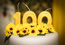 Nell'immagine una torta con le candeline a formare il numero 100 - Smart Marketing