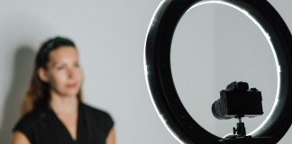 Nell'immagine una ragazza realizza un contenuto video con una fotocamera dotata di ring light - Smart Marketing