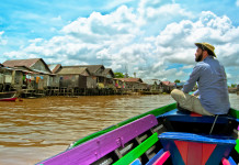 Nella foto il viaggiatore e scrittore Gaetano Appeso seduto su una barca naviga un fiume del sud est Asiatico - Smart Marketing