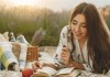 Nell'immagie una ragazza legge un libro durante un picnic sulla spiaggia - Smart Marketing