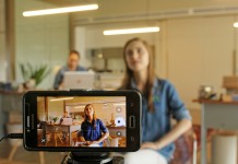 Nell'immagine una ragazza registra un video con lo smartphone - Smart Marketing