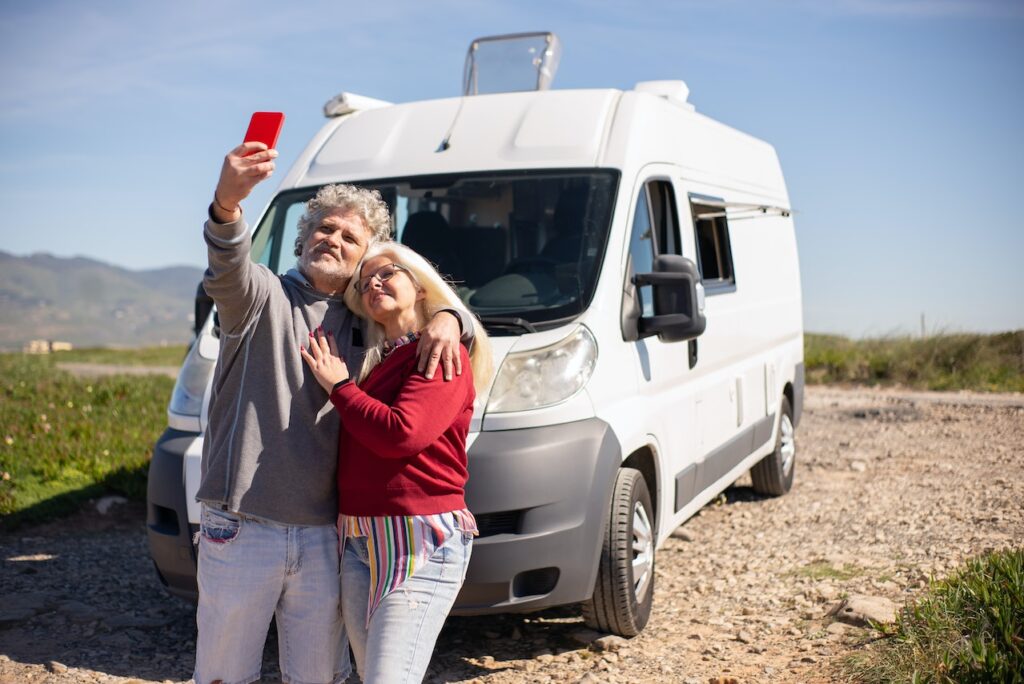 Nell'immagine una coppia si scatta un selfie davanti ad un camper - Smart Marketing