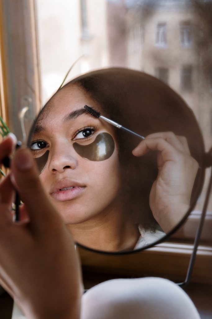 Nella foto una ragazza si trucca davanti ad uno specchio - Smart Marketing