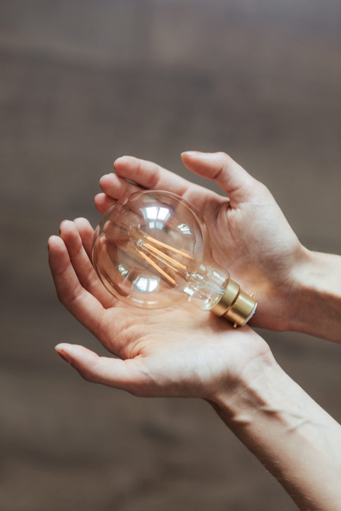 Nell'immagine due mani giunte tengono una lampadina - Smart Marketing