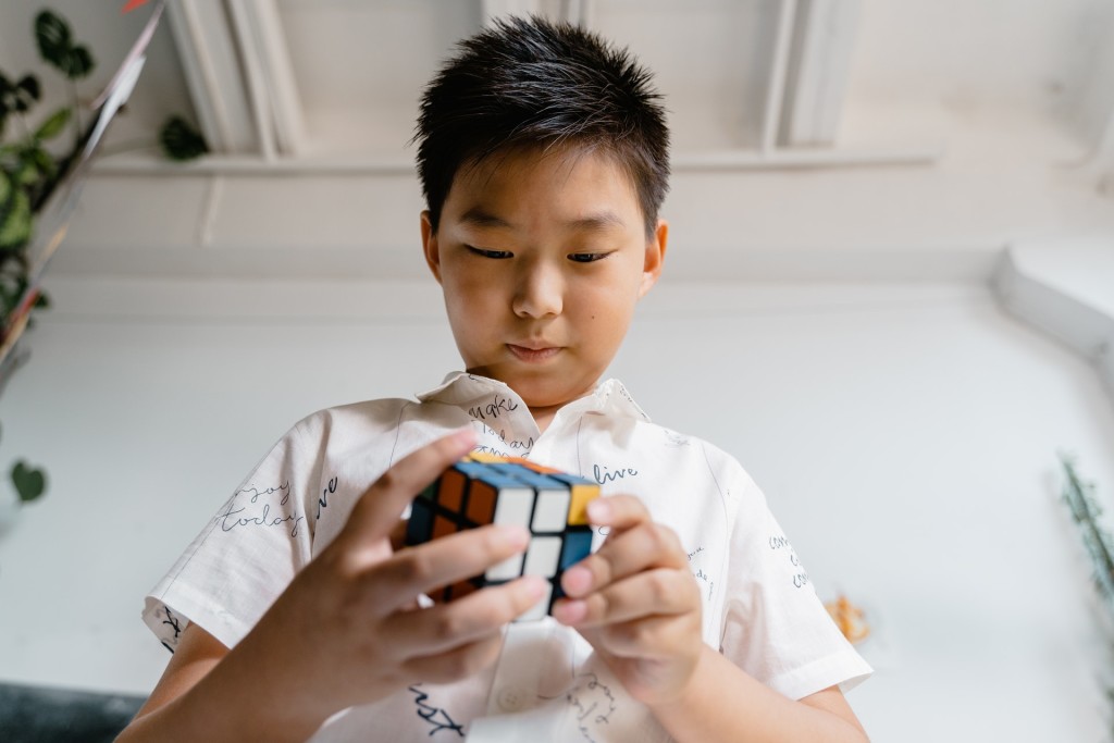 Nell'immagine un ragazzo tenta di risolvere il cubo Rubik - Smart Marketing