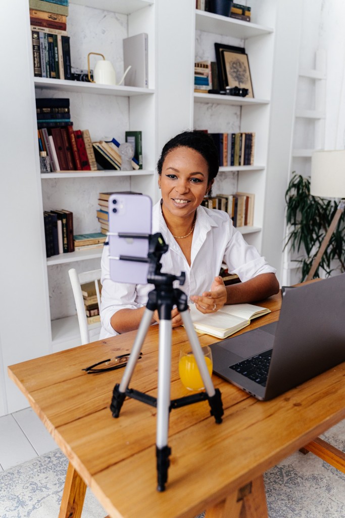 Nell'immagine una ragazza durante una video call con alle spalle una libreria - Smart Marketing