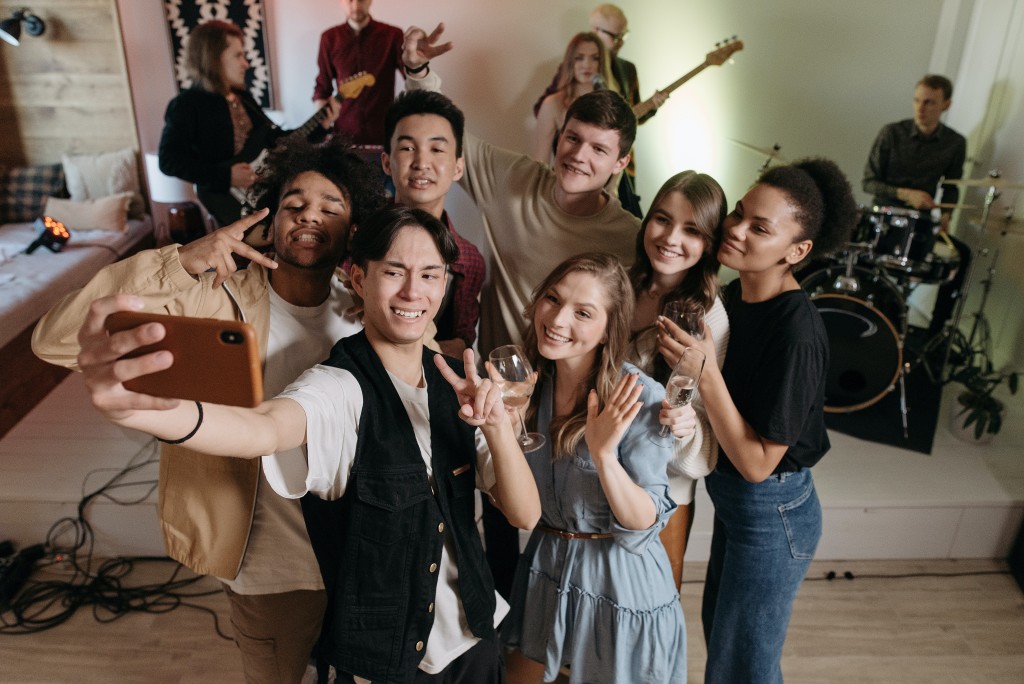 Nell'immagine un gruppo di ragazzi si fa un selfie - Smart Marketing