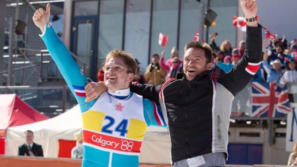 Nell'immagine gli attori Taron Egerton e Hugh Jackman in una scena del film “Eddie the Eagle - Il coraggio della follia” - Smart Marketing