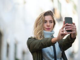Nell'immagine una ragazza si scatta un selfie - Smart Marketing