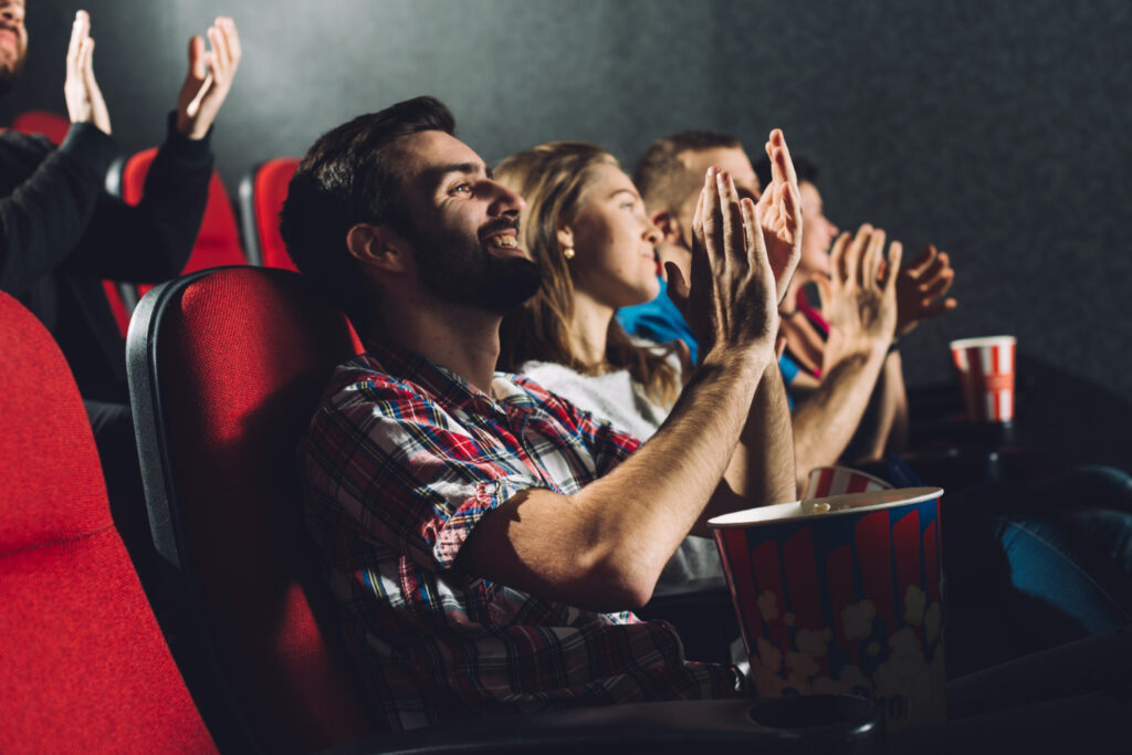 Nell'immagine gli spettatori di un cinema ridono guardando un film - Smart Marketing