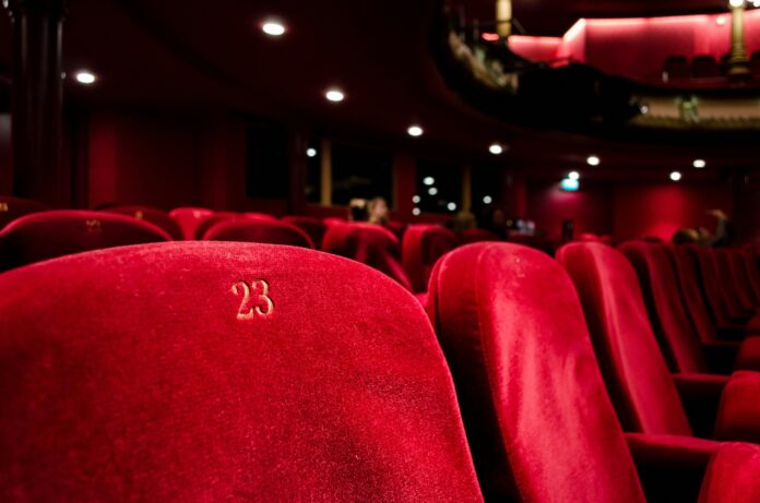 Nell'immagine le poltrone rosse di una grande sala cinematografica - Smart Marketing