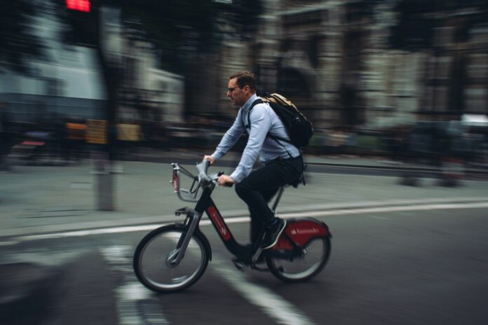 Nell'immagine un uomo pedala per recarsi al lavoro - Smart Marketing